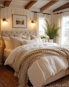 a bed with white linens and blankets in a bedroom