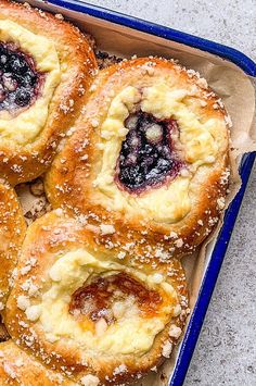 blueberry filled pastries in a baking pan with powdered sugar on the top