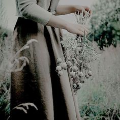 a woman is holding flowers in her hands