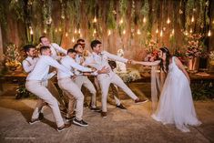 a group of people standing around each other in front of a table with flowers on it