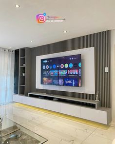 a flat screen tv mounted on the wall in a living room with marble flooring