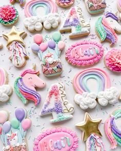 decorated cookies with unicorns, rainbows and stars on white paper next to confetti