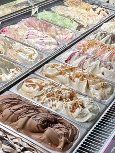 an assortment of ice creams in trays on display