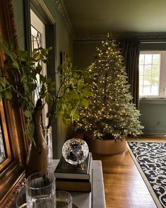 a living room with a christmas tree in the corner and other decorations on the table