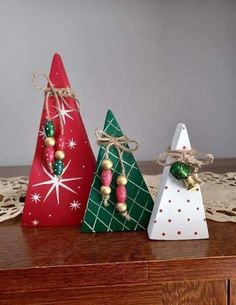 three small christmas trees are sitting on a table