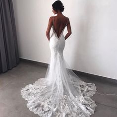 the back of a woman's wedding dress, with an open back and lace detailing