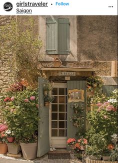 an old building with potted plants and flowers outside