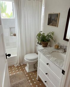 a bathroom with a sink, toilet and bathtub next to a window in it