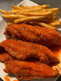 fried chicken and french fries on a plate with ketchup, sauce and mustard