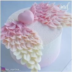 a close up of a cake with pink and white icing on it's side