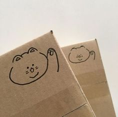 two brown boxes with drawings on them and one has a cat drawn on the side