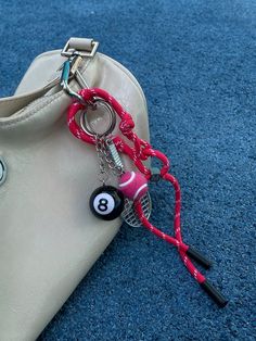 a purse with a keychain attached to it on the floor next to a pair of scissors