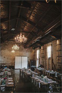 an empty dining room with chandelier and tables set up for a formal function