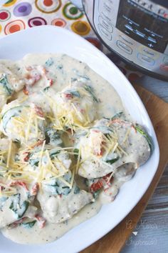 a white plate topped with ravioli and cheese next to an instant pressure cooker