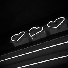 a neon sign that says love with hearts on it's backliting surface