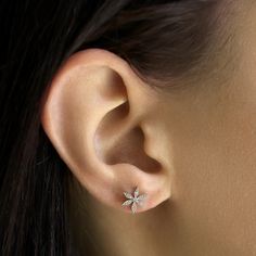 a woman's ear with a small flower on it