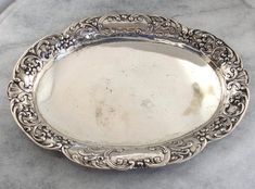 an ornate silver plate on a marble surface