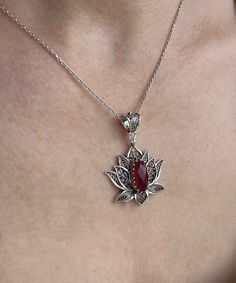 Introducing our stunning handcrafted filigree art blossoming lotus flower figured pendant necklace, featuring a breathtaking ruby corundum gemstone. This elegant necklace is made of high-quality 925 sterling silver and measures 20 inches in length, with a pendant height of 1.70 inches and a width of 1.20 inches. The July birthstone ruby corundum gemstone is a faceted oval cut that measures 7.00x14.00 mm, adding a touch of luxury to this already exquisite piece. Each necklace comes with a silver Elegant Flower Pendant Necklaces With Natural Stones, Teardrop Pendant Necklace With Intricate Design For Gift, Intricate Teardrop Pendant Necklace As Gift, Lotus Jewelry Design, Exquisite Flower Pendant Necklace As A Gift, Elegant Ruby Necklaces With Natural Stones, Flower Shaped Natural Stone Jewelry Gift, Ruby Filigree Jewelry As A Gift, Exquisite Flower Shaped Necklace For Gift