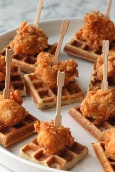 fried chicken and waffles on a plate with toothpicks in the middle