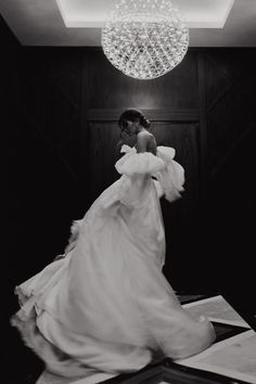 black and white photo of woman in wedding dress with chandelier above her head