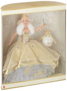 a barbie doll in a box with an ornament on the front and gold trimming