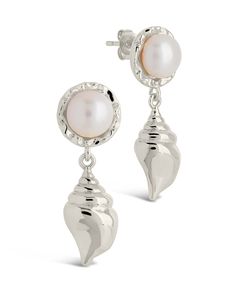 Elevate your style with our Beverly Drops Studs. These exquisite drop earrings feature a delicate combination of shells and pearls, creating a luxurious accessory that will effortlessly elevate any outfit. Make a statement of elegance and sophistication with the Beverly Drops Studs. Material: 14K gold or rhodium plated brass, freshwater pearls Features: 1.2" drop, 0.45" stud, 0.75" charm, 8mm pearls, Lead & Nickel free, post back Elegant Shell-shaped Pearl Earrings, Elegant Shell Pearl Earrings For Gift, Elegant Shell-shaped Pearl Earrings For Wedding, Silver Feminine Earrings With Pearl Charm, Elegant White Shell Pearl Earrings, Feminine Silver Earrings With Pearl Charm, Elegant Silver Shell Earrings, Silver Shell-shaped Earrings With Pearl Drop, Shells And Pearls