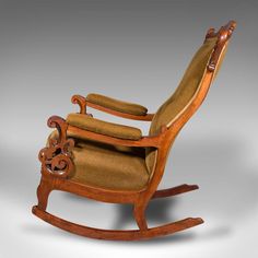 a wooden rocking chair with brown upholstered fabric