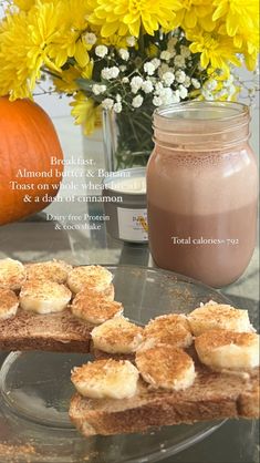 some food is on a glass plate near a vase with yellow flowers and a mason jar