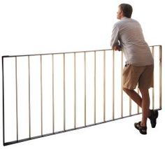 a man climbing up the side of a metal fence