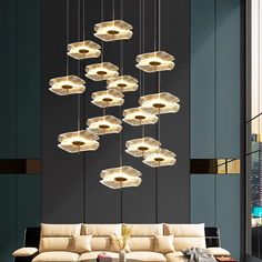 a living room filled with lots of furniture and lights hanging from it's ceiling