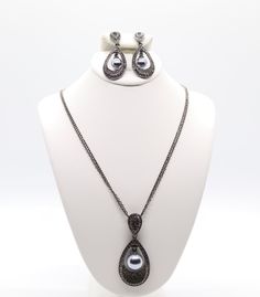 This jewelry set is a beautiful black earrings and necklace with a black pearl in the center. The earrings and necklace are made of high-quality materials and are sure to turn heads. Elegant Black Drop Earrings Jewelry, Elegant Teardrop Pendant Jewelry For Evening, Elegant Metal Jewelry Sets For Evening, Teardrop Pearl Drop Jewelry For Evening, Pearl Drop Teardrop Pendant Jewelry For Party, Party Pearl Drop Teardrop Pendant Jewelry, Teardrop Pendant Jewelry With Pearl Drop For Party, Evening Teardrop Pearl Drop Jewelry, Teardrop Metal Jewelry For Evening