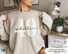 Step into your 40s in retro flair with our Hello 40 sweatshirt! This 40th birthday crewneck is a must-have for commemorating your Fortieth birthday in classic style. It also makes an ideal 40th birthday gift. ✨Please check the SIZE CHART image on the listing, and choose your size accordingly before placing your order.  🚫We do not accept exchanges, returns, or cancellations, however, if there are any print issues with the item please contact us right away. We'll be happy to make things right and Casual Birthday Sweatshirt With Lettering, Casual Sweatshirt With Lettering For Birthday, Hello 60, Hello Thirty, Hello 40, Twenty First Birthday, Sixtieth Birthday, 40th Birthday Shirts, Fifty Birthday