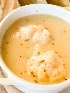 two dumplings are in a white bowl with broth