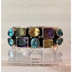 This is part of Chairish’s Fine Jewelry assortment.  This stunning vintage Sterling Cuff Bracelet with Semi Precious Stones will be a fabulous addition to your jewelry collection. The semi-precious stones (blue topaz, citrine, aquamarine, peridot and amethyst) in a variety of shapes and set in heavy gauge sterling silver make this Paul Livingston piece a real standout. Formal or casual, this beautiful Native American sterling bangle will be your go to when you want to impress. From my personal c Multicolor Multi-stone Bangle, Fusion Style Gemstone Cuff Bracelet, Multicolor Multi-stone Bangle As A Gift, Bohemian Multi-stone Gemstones For Anniversary, Unique Multi-stone Bangle Bracelet, Unique Multi-stone Bangle Bracelets, Unique Multi-stone Bangle, Unique Multi-stone Bangle Jewelry, Multicolor Gemstone Cuff Bracelet As Gift