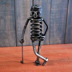 a small metal figure standing on top of a wooden table