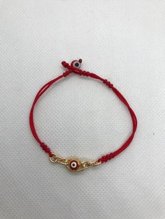 "Pulsera hecha a mano con el ojo rojo para la proteccion en oro chapeado terminado con hilo rojo reforzado delgado. hecha exclusivo para mujer. pulsera ajustable y expandible con cierre de candado minimo de 6.5\" pulgadas y maximo de 7\" pulgadas Aviso : si no es de su medida la pulsera; contactenos antes de comprar porque podemos hacer la medida que desea material: hilo rojo reforzado #A bola del mal ojo rojo 6mm cadena y del mal ojo en oro chapeado" Bohemian Red Evil Eye Jewelry, Handmade Red Evil Eye Bracelet For Gift, Red Evil Eye Bracelets For Good Luck, Gold Adjustable Evil Eye Bracelet For Good Luck, Red Bohemian Evil Eye Jewelry, Red Evil Eye Bracelet For Good Luck, Red Metal Bracelet With Adjustable Chain, Adjustable Red Evil Eye Jewelry, Adjustable Red Bracelets With Evil Eye