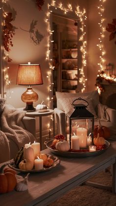 a living room with candles and pumpkins on the table