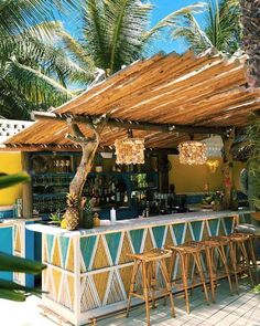 an outdoor bar with stools and palm trees