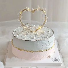 a wedding cake with white frosting and gold decoration