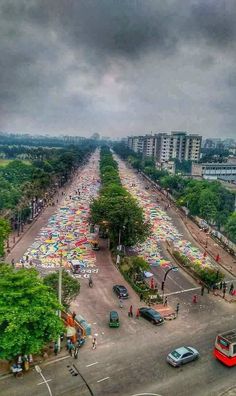 an aerial view of a city street with many umbrellas on the ground and people walking around