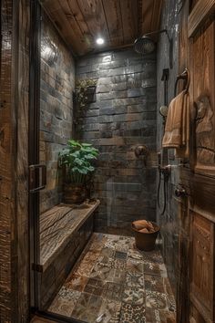 a rustic bathroom with stone walls and wood trimmings on the shower door, along with a plant