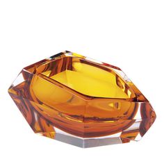 an orange glass object sitting on top of a white surface