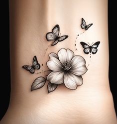 a woman's tattoo with butterflies and flowers on her side, as well as the butterfly