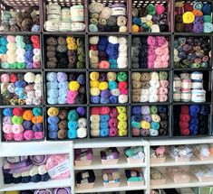 the shelves are filled with yarn and crochet hooks for storage, including balls of yarn