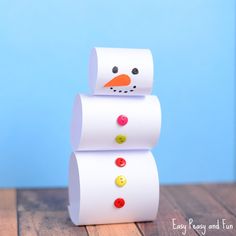 a snowman made out of toilet paper sitting on top of a wooden table