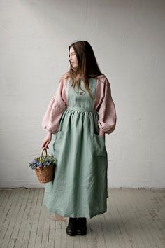 a woman in a green dress holding a basket