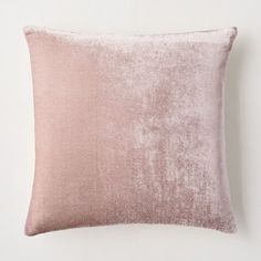 a pink velvet pillow sitting on top of a white wall