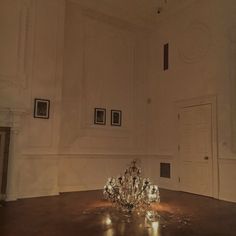 an empty room with some lights on the floor and pictures on the wall behind it