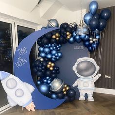 an astronaut balloon arch with blue and silver balloons