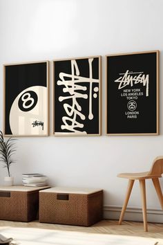 three black and white posters hanging on the wall above a chair in a living room